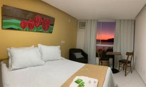 アングラ・ドス・レイスにあるPousada Costão do Solのベッドルーム1室(ベッド1台、テーブル、窓付)