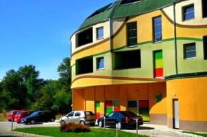 a colorful building with cars parked in front of it at Detelina Complex in Hisarya