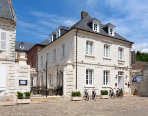 grupa rowerów zaparkowanych przed budynkiem w obiekcie HÔTEL JEAN DE BRUGES w mieście Saint-Riquier