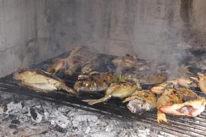 a bunch of dead fish cooking on a grill at Kaprije apartmani Tina i Ena in Kaprije