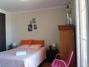 a bedroom with a bed and a pink chair at Las Arenas 112 - Atico vista al mar in Isla Canela +38 photos