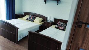 a bedroom with two beds and a door open at Emada- Pokoje Gościnne i Studia in Ostrowo