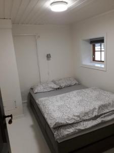 1 dormitorio con 1 cama en una habitación blanca en Bodvarstova, en Stryn