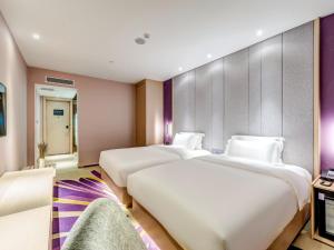 Un ou plusieurs lits dans un hébergement de l'établissement Lavande Hotel Tianjin Joy City Gulou Subway Station