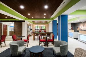 a lobby with tables and chairs and a kitchen at Holiday Inn Express Hillsville by IHG in Hillsville