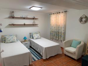 a room with two beds and a chair in it at Casa das Roseiras in Ferragudo +40 photos