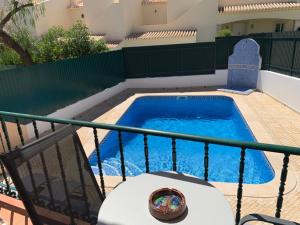 a small swimming pool with a table and a chair at Casa das Roseiras in Ferragudo