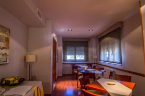 a dining room with tables and chairs and windows at Midama in Chillarón de Cuenca