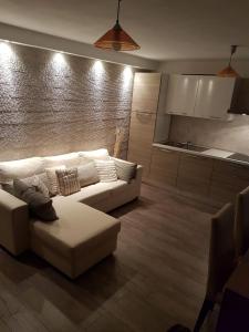 a living room with a white couch and a kitchen at Casa con Giardino in Olbia