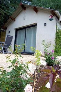 uma casa com uma grande janela e algumas flores em Cottage-Gite & Jacuzzi - Chez Flo & Marc em Chouzy-sur-Cisse