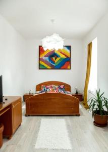 1 dormitorio con 1 cama y una pintura en la pared en Pensiunea Lms, en Brăila