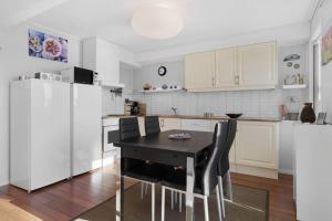 a kitchen with a black table and white appliances at Seaside Holiday Home, great for fishing & hiking in Hellesøyni