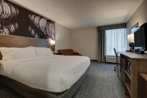 a hotel room with a large bed and a television at Clarion Pointe Hopkinsville near The Bruce Convention Center in Hopkinsville +10 photos