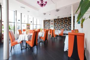 a dining room with tables and orange chairs at Islington Inn in London