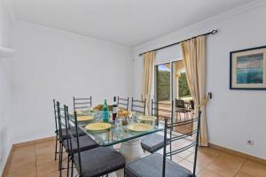 uma sala de jantar com uma mesa de vidro e cadeiras em Villa White Sands - Private Oasis, Heated Pool, Beaches & Strip Nearby em Albufeira