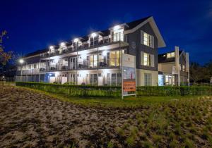 a building with a sign in front of it at night at Strandplevier Suites in De Koog