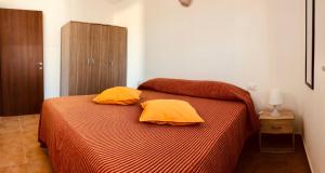 Un dormitorio con una cama con dos almohadas amarillas. en Siniscola Casa vacanze Olmo, en Siniscola