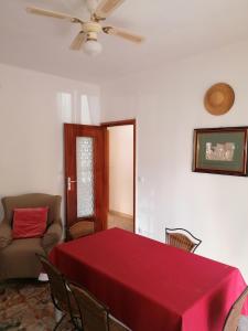 jadalnia z czerwonym stołem i kanapą w obiekcie Ortensia - Sanremo Apartments w San Remo
