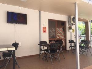 a room with tables and chairs and a tv on the wall at Cottage Euro Style in Ureki