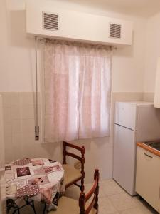 małą kuchnię ze stołem i lodówką w obiekcie Ortensia - Sanremo Apartments w San Remo