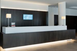 eine Lobby mit einer Rezeption und einem TV an der Wand in der Unterkunft Holiday Inn Express Antwerpen City North, an IHG Hotel in Antwerpen