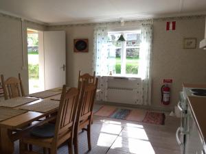 a dining room with a table and chairs and a window at Tättas stuga på Malingsbo Herrgård in Malingsbo