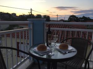 a table on a balcony with two glasses of wine at My Lemnos Studios - Studio 3 in Repanídhion