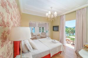 a bedroom with a bed and a large window at Orion Hotel in Nydri