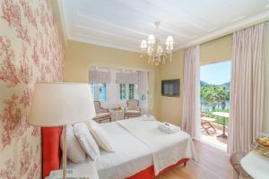 een slaapkamer met een bed en een groot raam bij Orion Hotel in Nydri