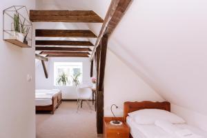 1 dormitorio con paredes blancas y techos de madera en Gostišče Krivograd, en Prevalje