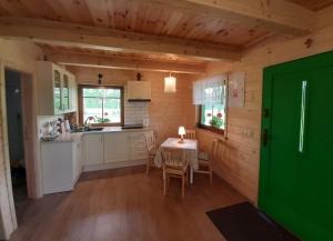 a kitchen and dining room with a table in a cabin at GREEN HOUSE in Krasnopol