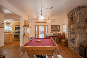 a pool table in a living room with a fireplace at Rental In Tahoe in South Lake Tahoe