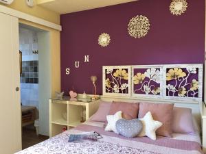 una camera da letto con un letto con pareti viola e lampadari a braccio di Cool Garden and Suite a Mairena del Aljarafe