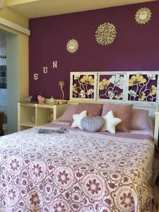 マイレナ・デル・アルハラフェにあるCool Garden and Suiteの紫の壁のベッドルーム1室(大型ベッド1台付)