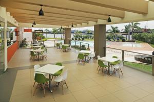 eine Cafeteria mit Tischen und Stühlen auf einer Terrasse in der Unterkunft Holiday Inn Express - Tuxpan, an IHG Hotel in Tuxpan de Rodríguez Cano