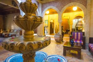 a living room with a fountain in the middle of a room at Riad Mimouna in Essaouira
