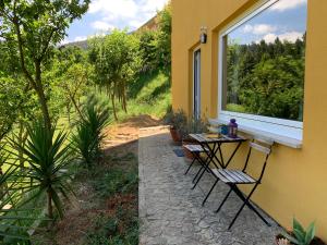 a patio with two chairs and a table and a window at Loft - Casinha à Porta in Arouca