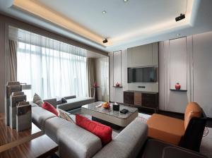 ein Wohnzimmer mit einem Sofa und einem TV in der Unterkunft HUALUXE Wuhu, an IHG Hotel in Wuhu