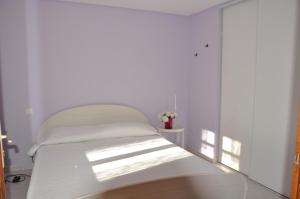 a white bed in a room with a window at Villa Petra in Sainte-Maxime