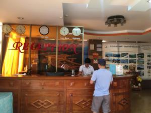 Due uomini in piedi al bancone di un ristorante di Khách sạn Bình Dương a Quy Nhon