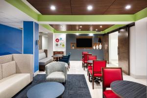 a waiting room with tables and chairs and a tv at Holiday Inn Express Hillsville by IHG in Hillsville