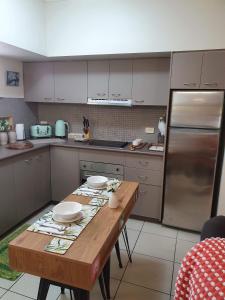 a kitchen with a wooden table and a refrigerator at Jackies City Central Apartment in Cairns