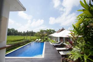 a villa with a swimming pool and a house at The Samara Villas & Restaurant in Ubud