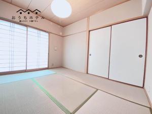 um quarto vazio com paredes e janelas brancas em OUCHI HOTEL Itsukaichi em Hiroshima