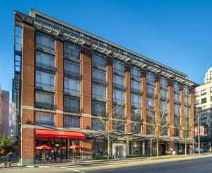 ein großes rotes Backsteingebäude in einer Stadtstraße in der Unterkunft OPUS Vancouver in Vancouver