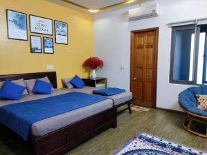a bedroom with two beds and a door and a chair at Kon-Tiki DaNang Hostel in Da Nang