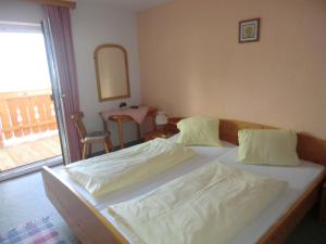 a bedroom with two beds and a table and a mirror at Apartment Leber in Ehrwald