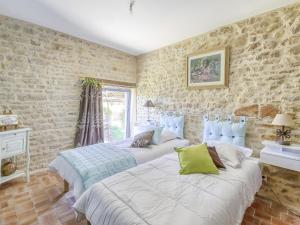 Habitación con 2 camas y paredes de piedra. en Burgundian Farmhouse in Talon with Fireplace, en Talon