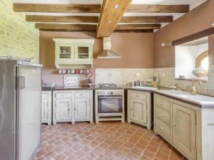 cocina con armarios blancos y nevera en Burgundian Farmhouse in Talon with Fireplace, en Talon