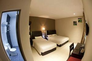 Postel nebo postele na pokoji v ubytování Ayer Hitam Hotel